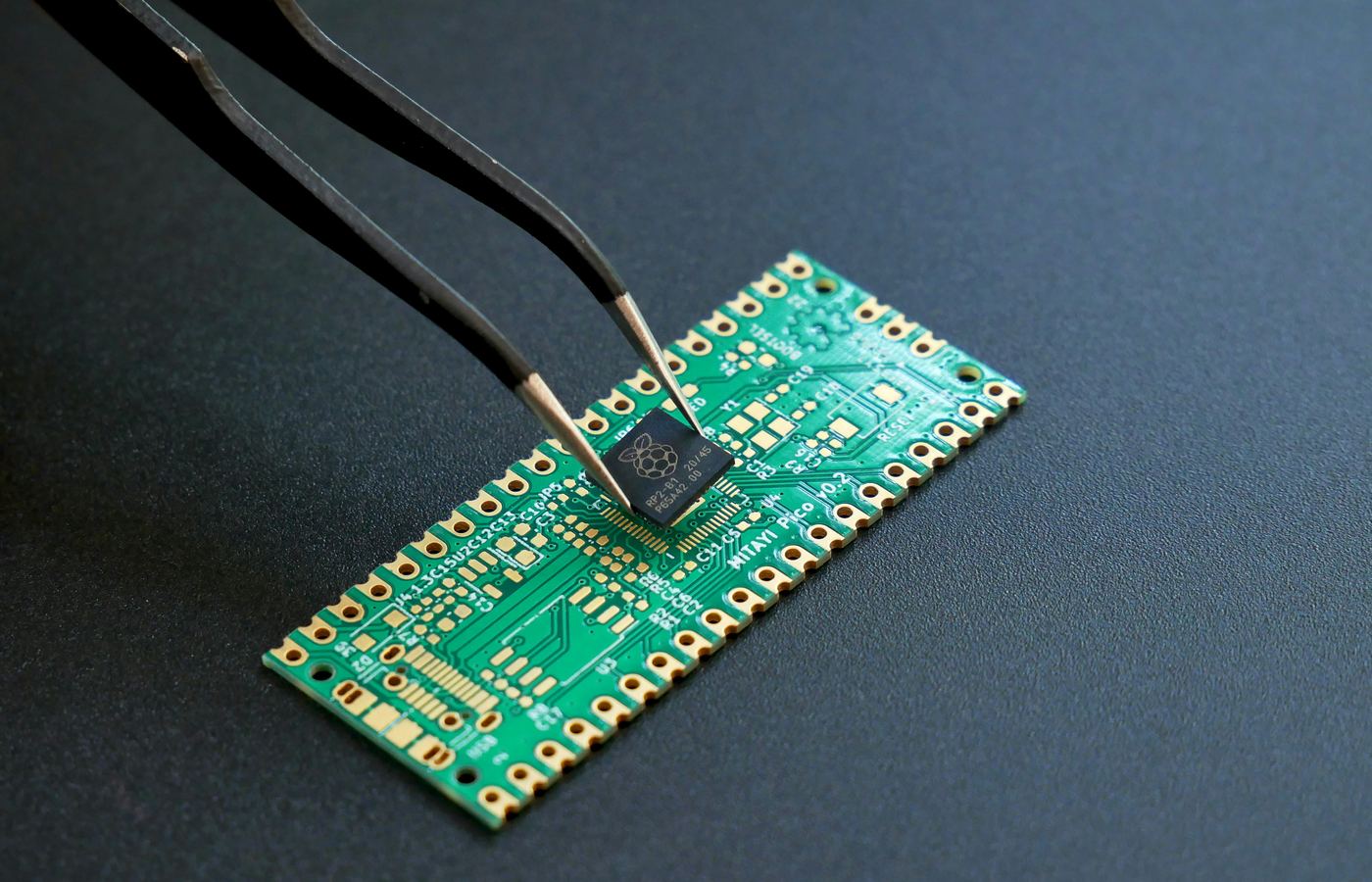 Close-up of a communications circuit board assembly with an embedded module being placed